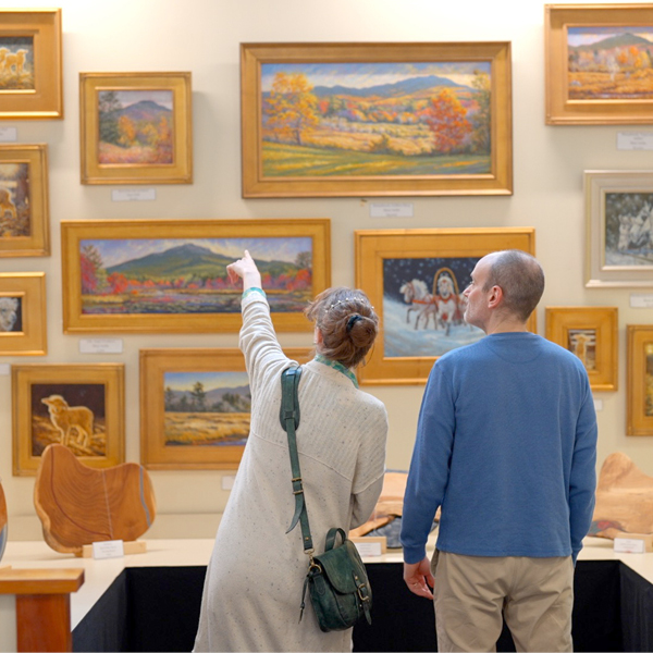 Couple point out paintings in a gallery